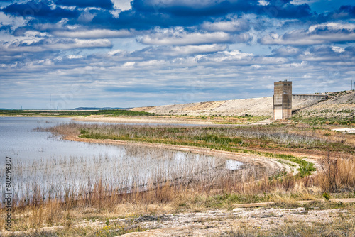 Εκτύπωση καμβά The grandiose architecture of San Angelo State Park in Texas rises out of the lush marshlands, its history visible against a shimmering lake and horizon full of fluffy clouds