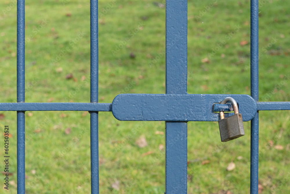 The gate is locked with a metal padlock. Close up