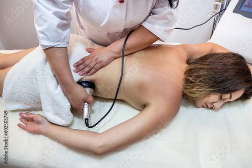 professional masseuse performs a cellulite treatment on the whole body with a special device.