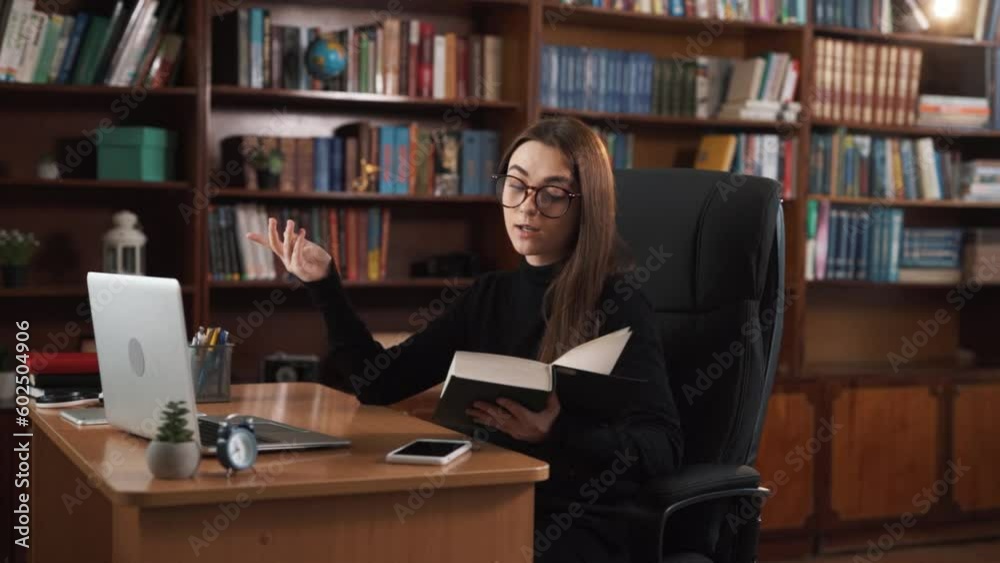 The girl engages in online communication through a webcam while sitting at her desk. She displays a book, reads selected excerpts from it with emotions, and explains their meaning. The girl engages in online communication through a webcam while sitting at her desk. She displays a book, reads selected excerpts from it with emotions, and explains their meaning.