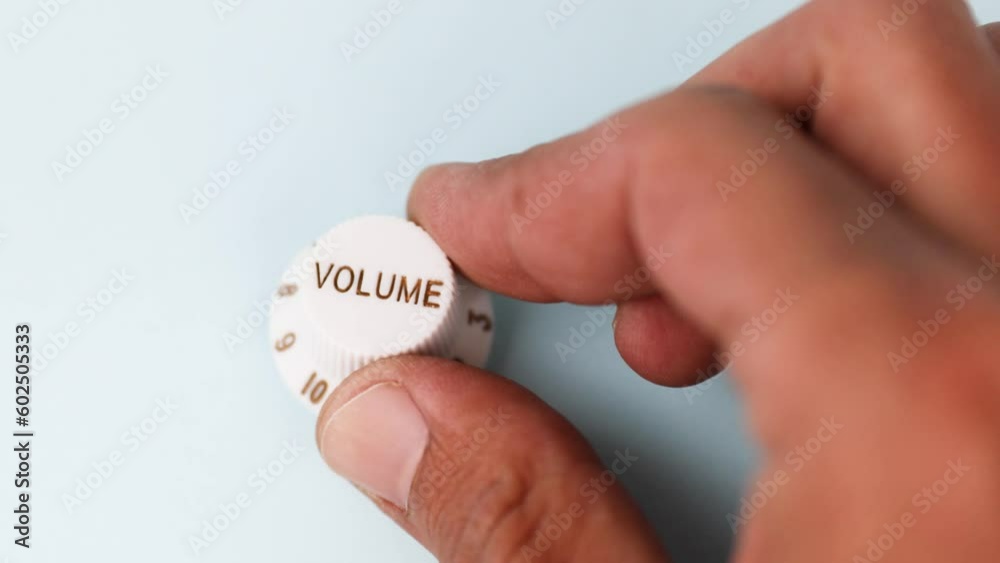 Close up of a black male hand turning volume level Close up of a black male hand turning volume level