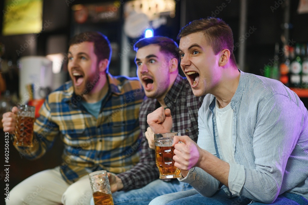 Sport, people, leisure, friendship, entertainment concept - happy male football fans or good yuong friends drinking beer, celebrating victory at bar or pub. Human positive emotions concept