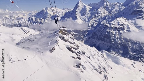 Scenic winter landscape in the Swiss Alps with famous peaks Eiger, Monk and Virgin seen from cabin of Schilthorn cable car on a sunny winter day. Photo taken March 19th, 2021, Switzerland.