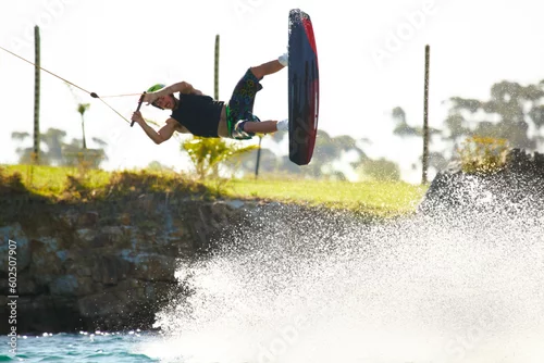 Obraz Training, wakeboard and extreme sports with man in lake for action, summer break and travel vacation. Wave, adrenaline junkie and fitness with guy surfing on river for health, adventure and speed