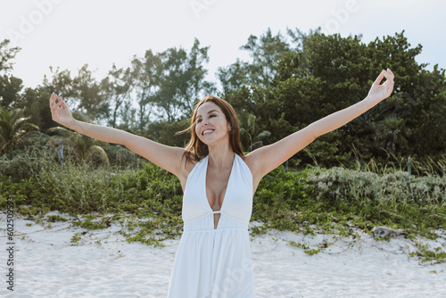 Happy latin woman with arms outstretched enjoying freedom at the beach in Mexico Latin America, hispanic positive people
