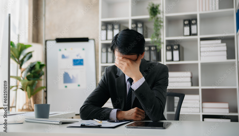 Asian businessman is stressed, bored, and overthinking from working on a tablet at the office. Asian businessman is stressed, bored, and overthinking from working on a tablet at the office.