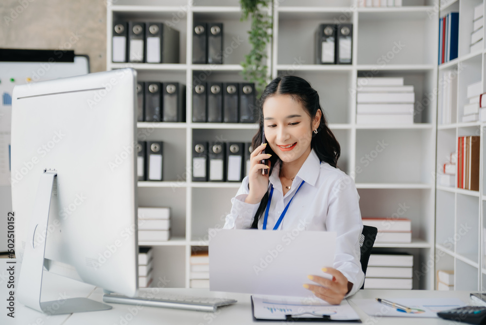 Beautiful Asian business woman typing laptop and tablet Placed at the table at home office Beautiful Asian business woman typing laptop and tablet Placed at the table at home office