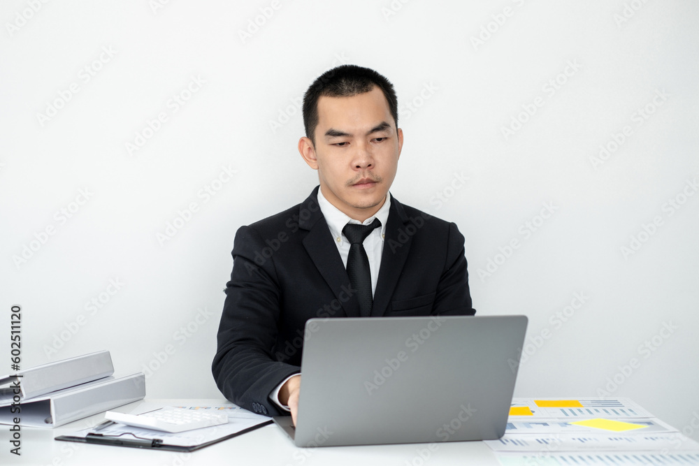 Smart businessman’s sitting in the office room and using computer to plan about marketing investment for his business. Smart businessman’s sitting in the office room and using computer to plan about marketing investment for his business.