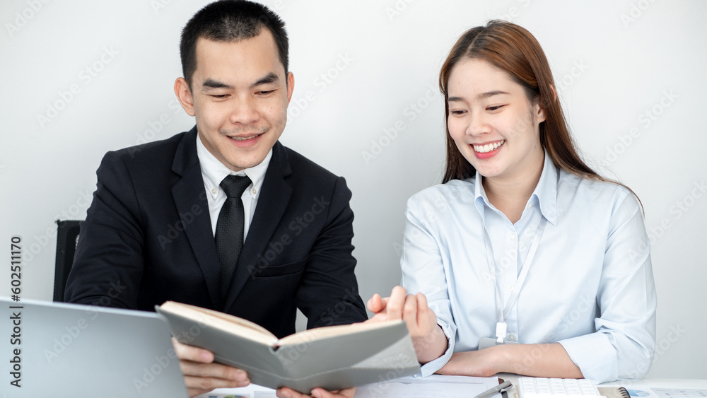 Two business people sitting at workplace and discussing about earnings on a graph to plan investments. Two business people sitting at workplace and discussing about earnings on a graph to plan investments.