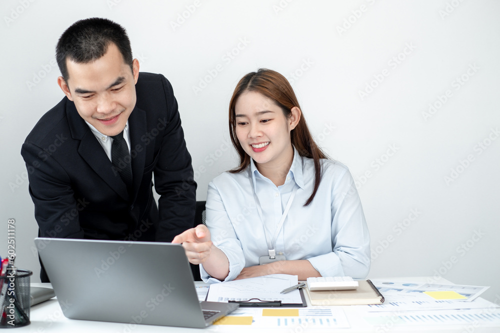 Two business people sitting at workplace and discussing about earnings on a graph to plan investments. Two business people sitting at workplace and discussing about earnings on a graph to plan investments.