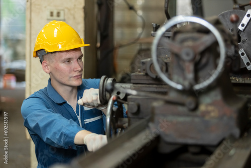 Caucasian man engineering workers wear yellow hard hat working machine lathe metal in factory industrial. mechanical operator male worker. Heavy industry concept.