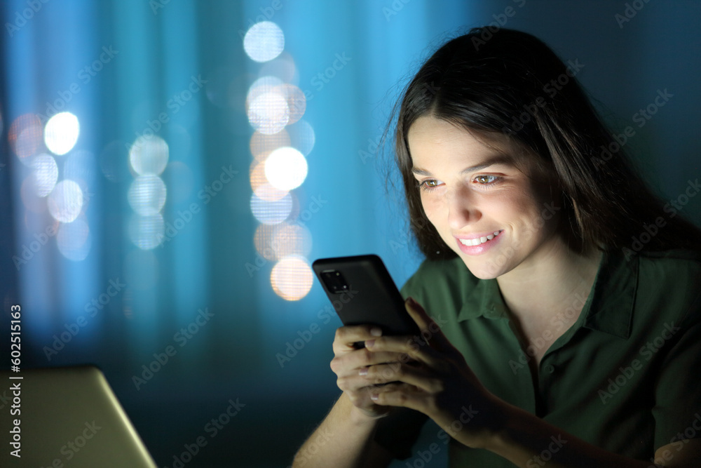 Woman in the night checking cell phone Woman in the night checking cell phone