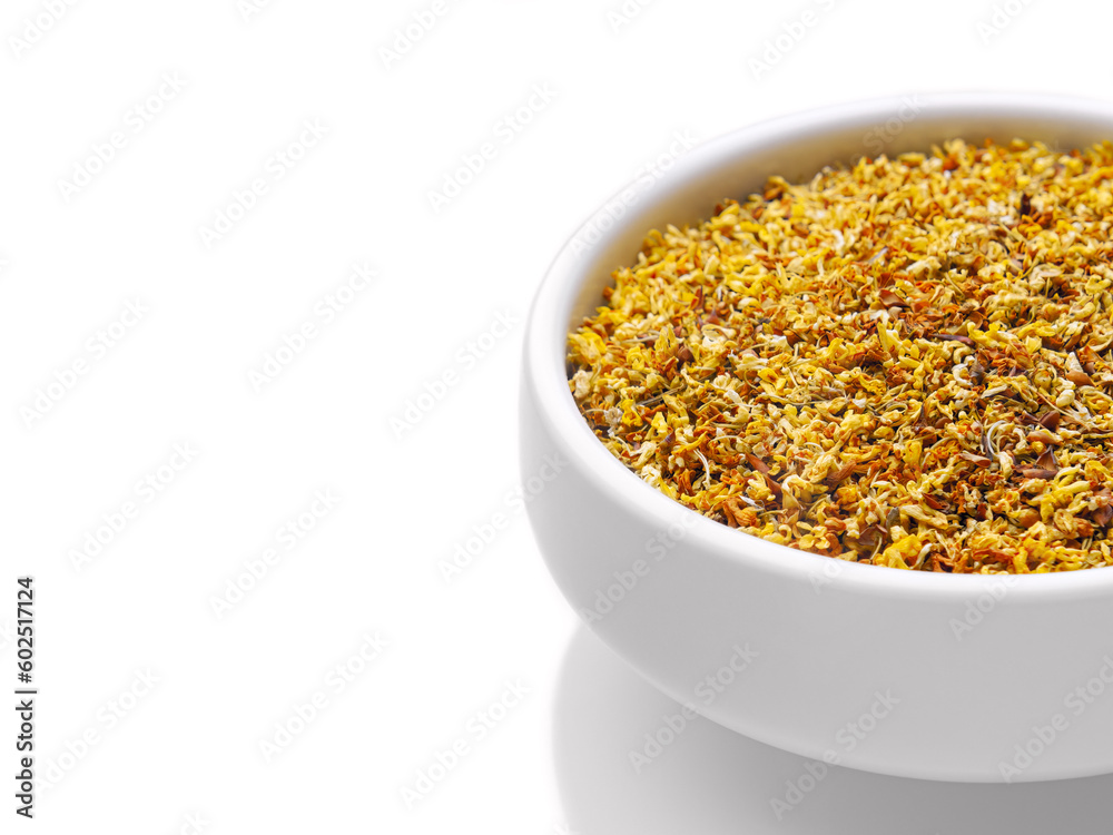 Dried osmanthus flowers in a white bowl on a white background. Half cup on the right, free space on the left, side view. Isolate. Herbal medicine. Therapeutic tea. Dried osmanthus flowers in a white bowl on a white background. Half cup on the right, free space on the left, side view. Isolate. Herbal medicine. Therapeutic tea.