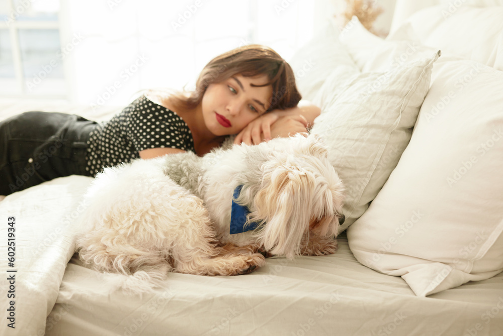 Side view image of pretty young girl and pet lying together comfortably and cuddling in bed, female watching her chinese crested dog sleeping, admiring and protecting its sleep, having rest at home Side view image of pretty young girl and pet lying together comfortably and cuddling in bed, female watching her chinese crested dog sleeping, admiring and protecting its sleep, having rest at home
