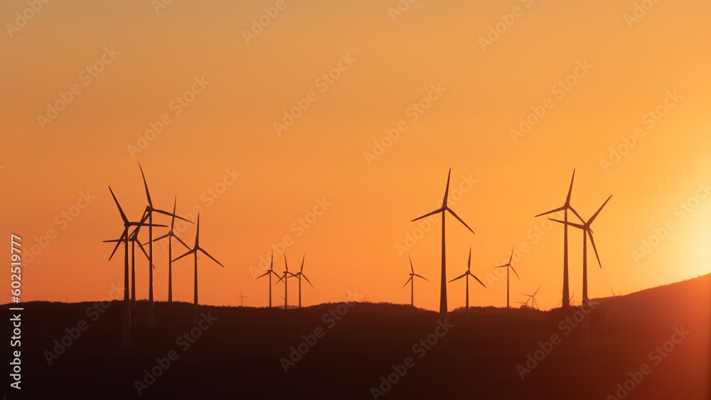 Obraz premium Windräder im Abendlicht bei Sonnenuntergang