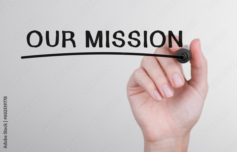 Womans hand writing word Our mission with marker Womans hand writing word Our mission with marker