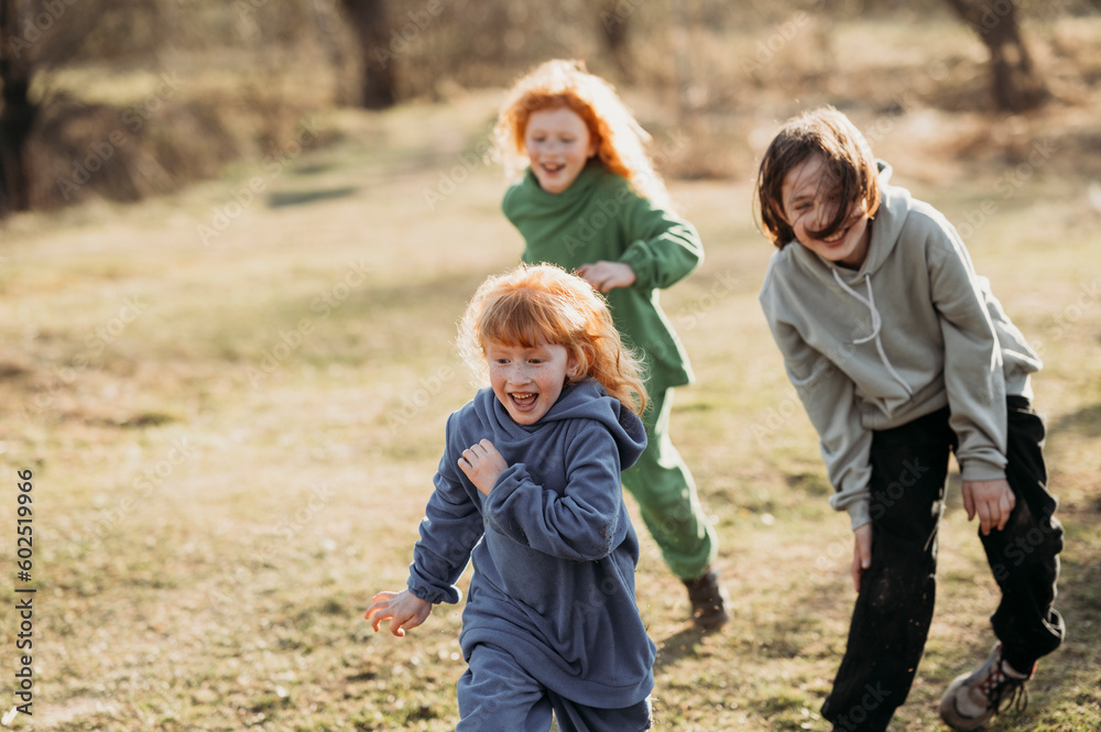 Cheerful children running in forest on sunny day Cheerful children running in forest on sunny day