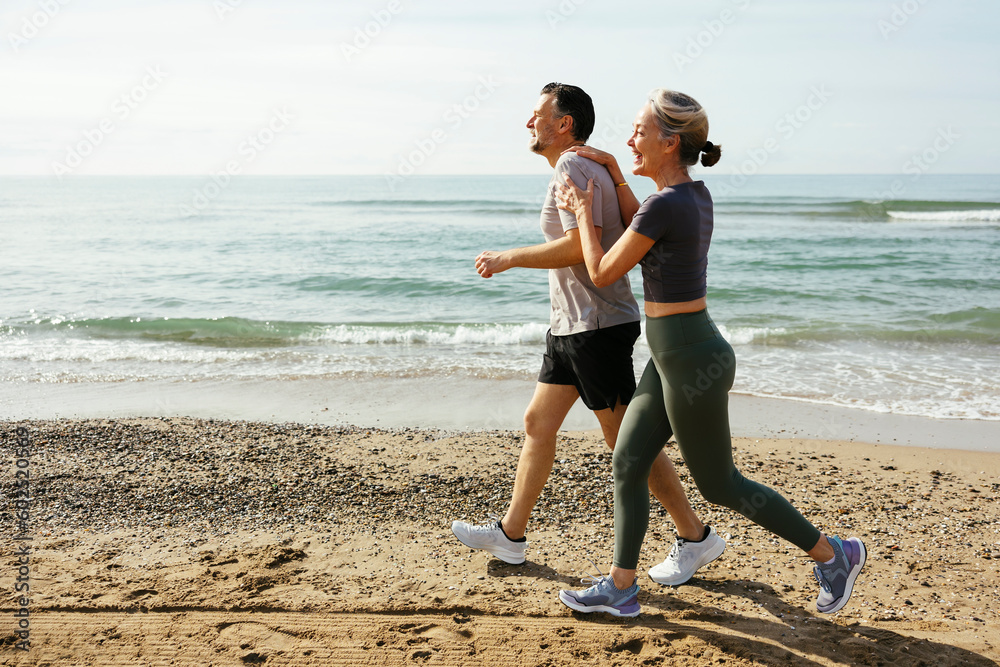 © Westend61 - Happy couple running and having fun at beach