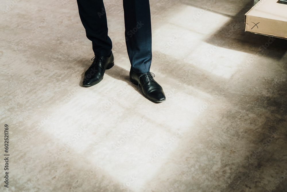 Businessman wearing shiny formal shoes standing on floor in factory Businessman wearing shiny formal shoes standing on floor in factory