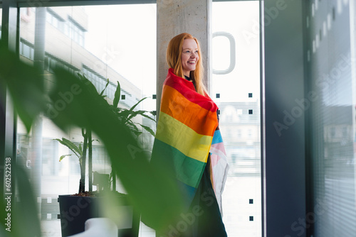 Smiling young woman with rainbow flag photo