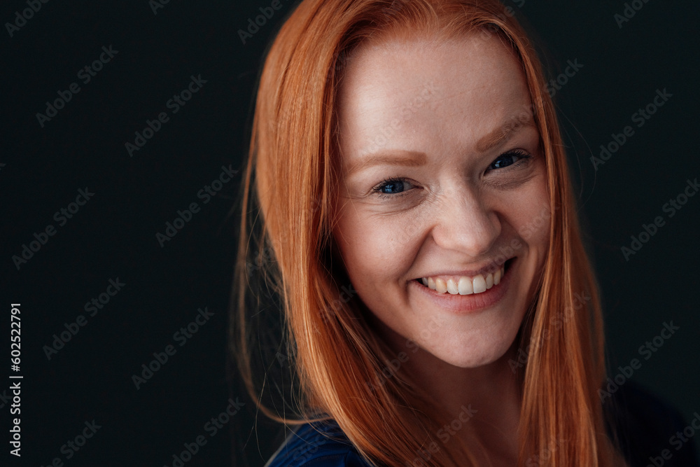 Cheerful redhead woman against black background Cheerful redhead woman against black background
