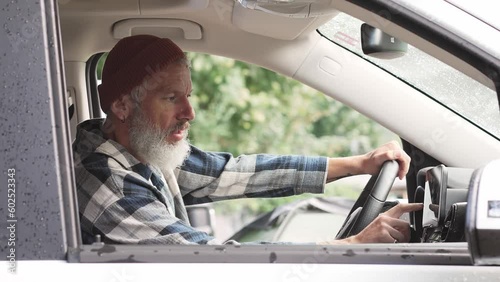 Older man sitting in camper van using gps navigation map system digital device. Smiling mature active traveler driving car vehicle looking at screen touching sensor gadget dashboard on the way.
