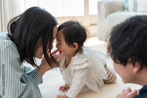 家のリビングで子供と遊ぶ日本人夫婦