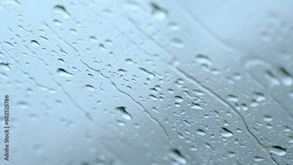 Rain water drops flowing down glass, waterdrops on window surface condensed liquid water droplets fall wet abstract background. Spring season showers raindrops condensate, sad atmosphere.