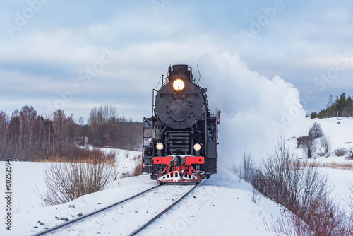 Retro steam train moves at winter morning,