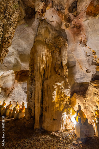 The Buddha statue is situated in a cave with a big pole caused by stalactite and stalagmite at Wat Khao Tham Ma Rong, Bang Saphan, Prachuap Khiri Khan, Thailand