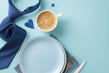 Set the mood for Father's Day with a lovely table arrangement. Flat lay top view of tableware, coffee, cutlery, napkin, tie, hearts on a pastel blue background with a blank space for text or ad