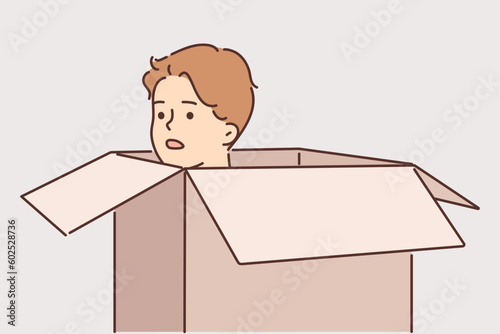 Frightened man hides in carton box trying to avoid meeting offender or unpleasant person