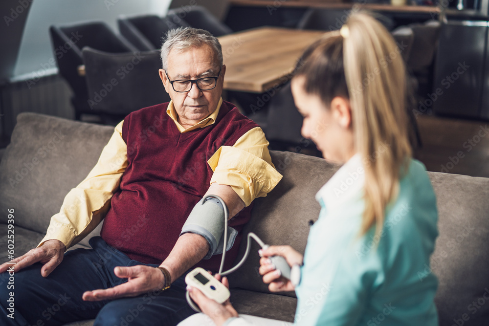 Home doctor is measuring blood pressure of old man at his home. Professional health support for elderly people. Home doctor is measuring blood pressure of old man at his home. Professional health support for elderly people.