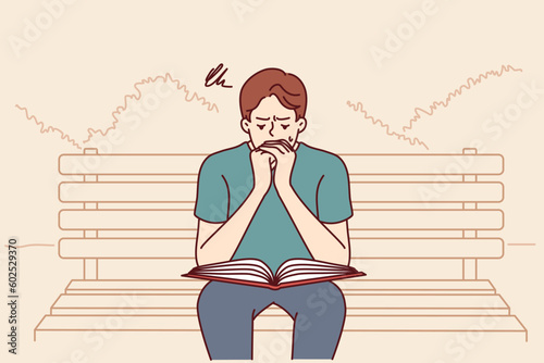 Man prays reads holy bible or gospel sitting on bench in public park. Believing guy turns to god and prays asking almighty from christian or catholic religion for help in solving problems