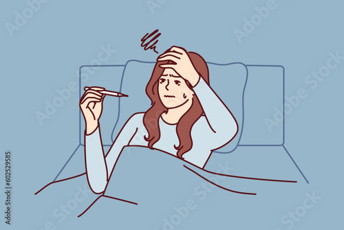 Sick woman with thermometer lies in bed under covers after being infected with viral infection and flu. Girl with thermometer suffers needing antibiotics or vaccine against dangerous disease.