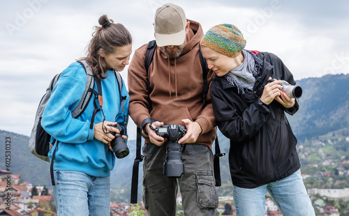 Obraz na plátne A group of young adult people friends colleagues professional photographers with cameras in their hands