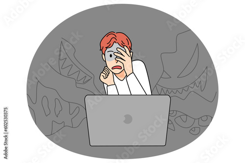 Scared boy watch horror movie on computer