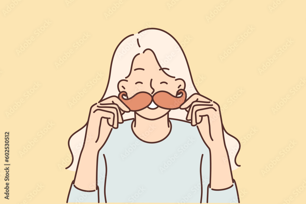 Cheerful girl puts cardboard mustache to face and laughs choosing funny mask for photo Cheerful girl puts cardboard mustache to face and laughs choosing funny mask for photo