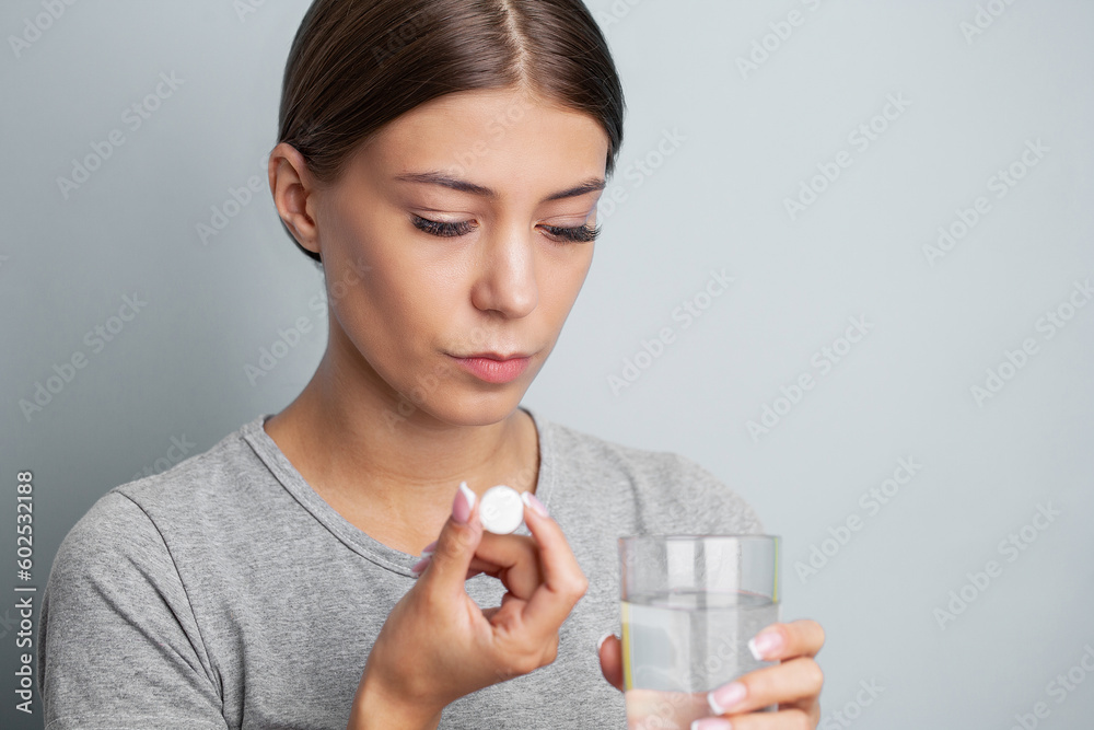 Woman holding pill and glass water, taking medicine from headache, stomach pain or taking vitamins Woman holding pill and glass water, taking medicine from headache, stomach pain or taking vitamins