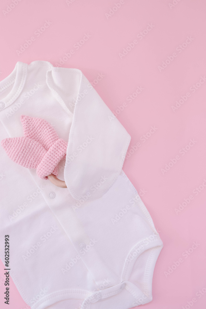White bodysuit on a pink background. Waiting for the girl. Pregnancy. Clothes for newborns White bodysuit on a pink background. Waiting for the girl. Pregnancy. Clothes for newborns