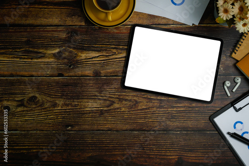 Flat lay, top view of digital tablet with white empty screen, financial document and coffee cup on wooden office desk