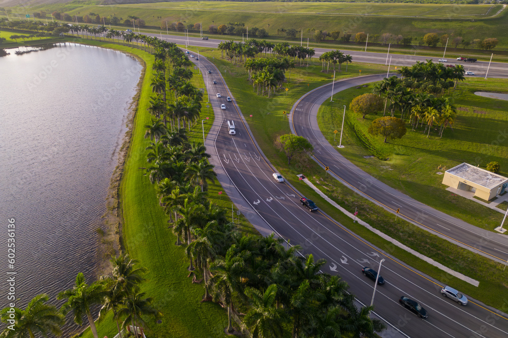 A highway with palm trees and a road that says miami