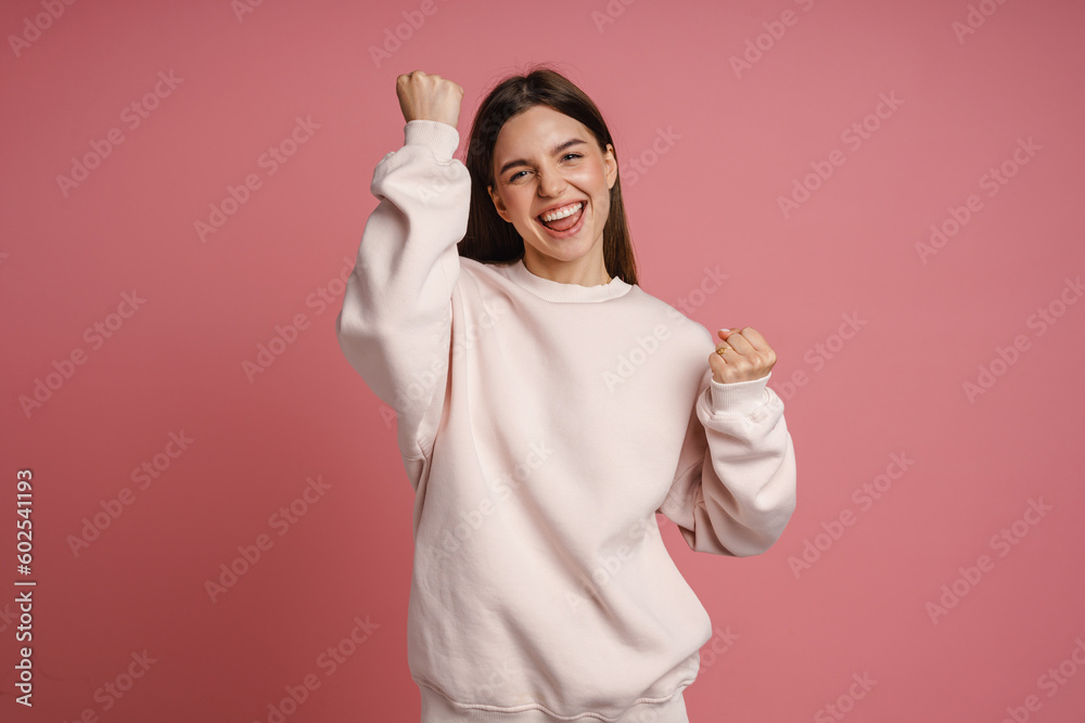 Excited woman screaming and celebrating success isolated over pink background Excited woman screaming and celebrating success isolated over pink background