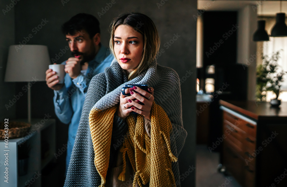 Freezing man and woman suffering from cold or flu fever or having trouble with central heating - obrazy, fototapety, plakaty 