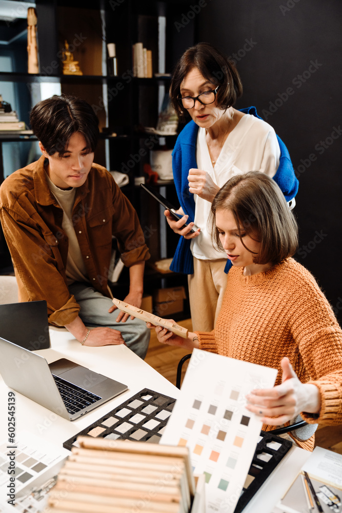 Fototapeta premium Group of architects choosing materials for interior design project in office