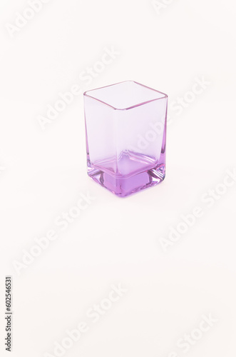 immagine con vista dall alto di elegante dal disegno moderno bicchiere vuoto  in cristallo violetto su una superficie bianca