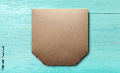 Box of cardboard pizza, blank unprinted on a blue wooden background, mockup top view