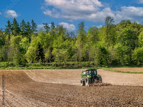 Farm tractor harrowing arable field