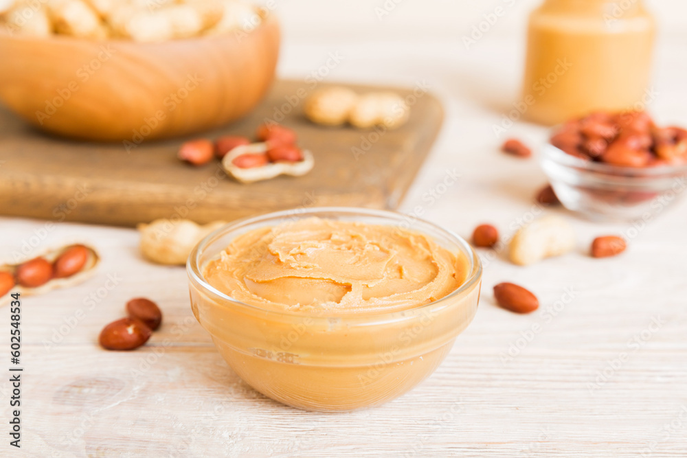 Bowl of peanut butter and peanuts on table background. top view with copy space. Creamy peanut pasta in small bowl Bowl of peanut butter and peanuts on table background. top view with copy space. Creamy peanut pasta in small bowl