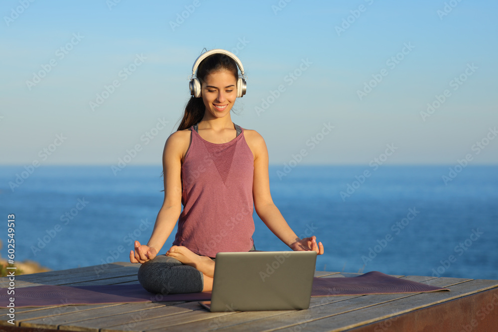 Fototapeta premium Yogi doing yoga watching video tutorial online